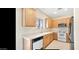 Well-lit kitchen featuring wood cabinets, white appliances, and a stainless steel sink with large window at 1869 E Birch St, Casa Grande, AZ 85122