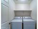 Functional laundry room with a side-by-side washer and dryer unit and a storage shelf at 2101 S Meridian Rd # 190, Apache Junction, AZ 85120