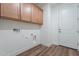 Functional laundry room with wood cabinets, utility connections, and a door to the exterior at 2121 W Sonoran Desert Dr # 93, Phoenix, AZ 85085