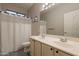 Bathroom featuring dual sinks, a large mirror, and a shower with a white curtain at 25622 N Singbush Loop, Phoenix, AZ 85083