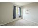 Bedroom with a window and light gray carpet, adorned with blue curtains at 25622 N Singbush Loop, Phoenix, AZ 85083