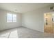 Bright bedroom with a window, neutral walls and gray carpet, and access to hallway at 25622 N Singbush Loop, Phoenix, AZ 85083