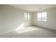 Bedroom featuring two windows, neutral walls, and soft, neutral-toned carpeting at 25622 N Singbush Loop, Phoenix, AZ 85083