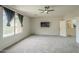 Bright main bedroom showcases neutral carpet, ceiling fan, and large windows with neighborhood views at 25622 N Singbush Loop, Phoenix, AZ 85083