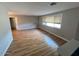 Bright living room featuring sleek wood flooring and ample natural light from a large window at 2605 E Geneva Dr, Tempe, AZ 85282