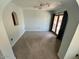 Bright living room featuring an arched window, neutral carpet, and a door with side windows leading to the outside at 2605 E Geneva Dr, Tempe, AZ 85282