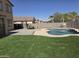 Backyard view showcasing the sparkling pool, lush artificial turf, and covered patio at 28273 N Castle Rock Dr, San Tan Valley, AZ 85143