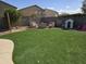 Backyard area with a cozy fire pit, seating, and a lush artificial turf lawn at 28273 N Castle Rock Dr, San Tan Valley, AZ 85143