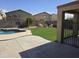 Spacious backyard with artificial turf, a cozy fire pit area, and mature landscaping at 28273 N Castle Rock Dr, San Tan Valley, AZ 85143