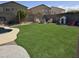 Lush backyard with artificial turf, mature trees, a firepit, and a basketball court at 28273 N Castle Rock Dr, San Tan Valley, AZ 85143