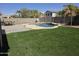 Large backyard with pool, patio area, artificial turf, and mature trees at 28273 N Castle Rock Dr, San Tan Valley, AZ 85143