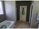 Bathroom area boasts tile floor, tub, and view into walk in closet at 28273 N Castle Rock Dr, San Tan Valley, AZ 85143