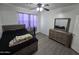 Relaxing bedroom with gray floors, ceiling fan, and wood dresser at 28273 N Castle Rock Dr, San Tan Valley, AZ 85143