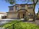 Two-story home featuring a two-car garage, manicured lawn, and a mix of stone and stucco finishes at 28273 N Castle Rock Dr, San Tan Valley, AZ 85143