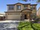 Inviting two-story home showcasing a brick-accented entryway and a well-maintained front lawn at 28273 N Castle Rock Dr, San Tan Valley, AZ 85143