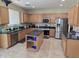 Spacious kitchen featuring stainless appliances, a kitchen island, and tile floors at 28273 N Castle Rock Dr, San Tan Valley, AZ 85143