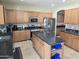 Eat-in kitchen boasts wood cabinets, stainless steel appliances, tile backsplash, and granite countertops at 28273 N Castle Rock Dr, San Tan Valley, AZ 85143