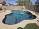 A backyard pool with a cascading water feature surrounded by a spacious concrete patio at 28273 N Castle Rock Dr, San Tan Valley, AZ 85143