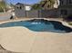 Inviting backyard pool with a soothing waterfall feature and a basketball hoop for added fun at 28273 N Castle Rock Dr, San Tan Valley, AZ 85143