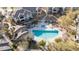 Overhead shot of a sparkling community pool and lounge area surrounded by lush trees and homes at 33575 N Dove Lakes Dr # 2028, Cave Creek, AZ 85331