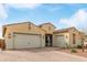 A house with a three-car garage and desert landscaping creates a warm, inviting curbside appeal at 3408 S 184Th Ln, Goodyear, AZ 85338