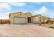 A wide, paved driveway leads to this house with three-car garage, complemented by desert landscaping at 3408 S 184Th Ln, Goodyear, AZ 85338