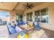 This covered patio is styled with wicker furniture, colorful pillows and a ceiling fan at 3408 S 184Th Ln, Goodyear, AZ 85338