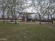 Community playground with climbing and play structures covered by a sun shade, surrounded by trees at 3408 S 184Th Ln, Goodyear, AZ 85338