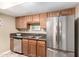 Kitchen with stainless steel appliances and wood cabinetry with granite countertops at 3511 E Baseline Rd # 1076, Phoenix, AZ 85042