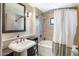 Bathroom featuring a shower-tub combo, white sink, and dark wood accent cabinets at 36601 N Mule Train N Rd # D16, Carefree, AZ 85377