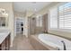 Spa-like bathroom featuring a walk-in shower and a luxurious soaking tub at 3931 N 163Rd Dr, Goodyear, AZ 85395