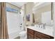 Bathroom with a tub-shower combination, dark wood vanity, and a large mirror at 3931 N 163Rd Dr, Goodyear, AZ 85395