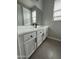 Bathroom with dual sinks, modern fixtures, white cabinetry, and tile floors at 41260 W Palmyra Ln, Maricopa, AZ 85138