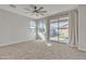 Cozy bedroom featuring carpeted floors, a ceiling fan, and a sliding glass door for natural light at 41260 W Palmyra Ln, Maricopa, AZ 85138