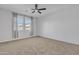 Comfortable carpeted bedroom with large window allowing natural light, complemented by soft neutral tones at 41260 W Palmyra Ln, Maricopa, AZ 85138