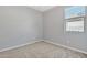 Well-lit bedroom featuring neutral carpeting and a window at 41260 W Palmyra Ln, Maricopa, AZ 85138