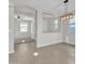 Bright dining room features modern light fixture, gray tile flooring, and neutral paint, creating an inviting space at 41260 W Palmyra Ln, Maricopa, AZ 85138