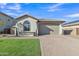 Charming home featuring a manicured lawn and a paver driveway leading to a two-car garage at 41260 W Palmyra Ln, Maricopa, AZ 85138