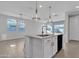 Large kitchen island with sink and granite countertop, complemented by stylish pendant lighting at 41260 W Palmyra Ln, Maricopa, AZ 85138