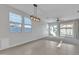 Spacious living area with tile floors, a modern light fixture, and plenty of natural light at 41260 W Palmyra Ln, Maricopa, AZ 85138