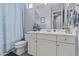 Bathroom featuring a light blue shower curtain and white cabinets at 4457 E Bernice St, Gilbert, AZ 85295