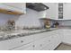 Close-up of a granite kitchen counter with white cabinets and stainless steel appliances at 4457 E Bernice St, Gilbert, AZ 85295