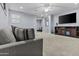 Comfortable living room with a gray sofa, TV, ceiling fan and neutral carpet at 4457 E Bernice St, Gilbert, AZ 85295