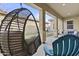 Covered patio view with hanging lounge chair, blue lounge chairs, and artificial grass and putting green at 4457 E Bernice St, Gilbert, AZ 85295