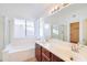 Bright bathroom with double sinks, a large mirror, and a separate tub and shower at 4881 S Vista Pl, Chandler, AZ 85248