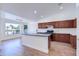 Bright kitchen with cherry cabinets, a central island, and a view of the dining area with scenic waterfront views at 4881 S Vista Pl, Chandler, AZ 85248