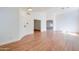 Spacious living room with wood floors, neutral walls, modern lighting, and an open archway leading to another room at 4881 S Vista Pl, Chandler, AZ 85248