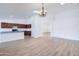 Open-concept living space with wood floors and a view into the kitchen with cherry cabinets and a large island at 4881 S Vista Pl, Chandler, AZ 85248