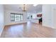 Elegant living room with wood flooring, large windows offering lake views, and an adjacent modern kitchen at 4881 S Vista Pl, Chandler, AZ 85248