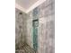 Luxurious shower features stone tile, decorative mosaic detail, and a built-in shelf for toiletries at 4881 S Vista Pl, Chandler, AZ 85248